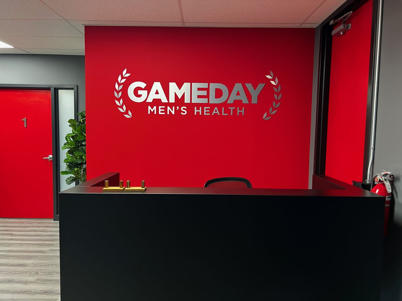 Reception at Game Day Men's Health West Oakville, 710 Dorval Drive — GameDay logo wall behind the front desk